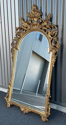 un miroir posé par terre près d'un mur