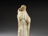 une figurine en ivoire représentant une femme tenant un enfant dans ses bras