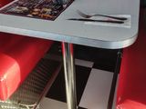 a red booth with two red chairs and a white table