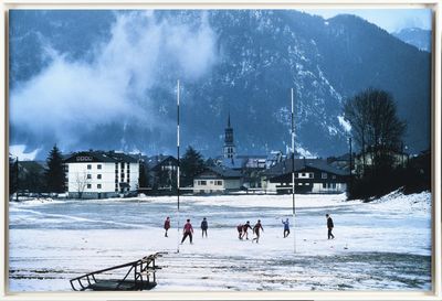 un groupe de personnes jouant au football sur un terrain enneigé