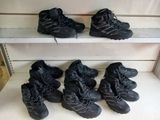 six paires de chaussures de randonnée noires sont alignées sur une étagère