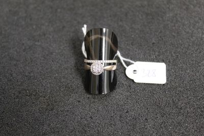 gros plan d'une bague sur une surface noire avec une étiquette de prix