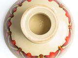a white vase with a red and yellow design on it