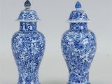 une paire de vases bleus et blancs surmontés d'oiseaux