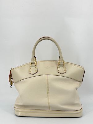 a white leather handbag with gold hardware on the handles