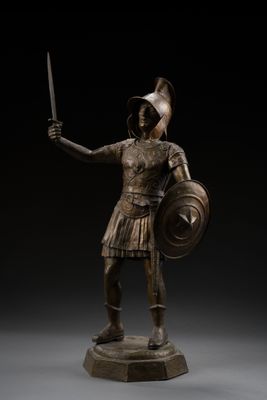 a bronze statue of a roman soldier holding a sword and shield