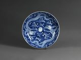 une assiette bleue et blanche ornée d'un motif représentant un dragon