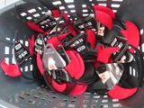 many pairs of shoes in a basket with tags on them