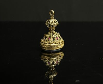 une clochette dorée sur une surface noire, avec un reflet