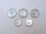 six silver and white glass buttons on a white surface