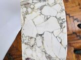 someone is standing on the floor next to a table with a marble slab on it