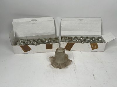 deux boîtes de vis et d'écrous posées sur une surface blanche