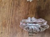a glass vase with a flower in it sitting on a table