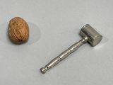 a nut and a hammer on a white surface