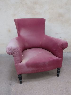 a pink chair that is sitting in front of a wall