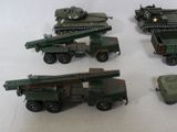 several toy army vehicles are lined up on a white surface