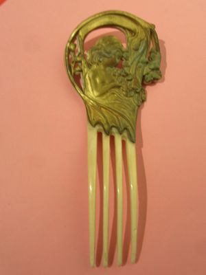 un peigne à cheveux de couleur dorée orné d'un visage vert