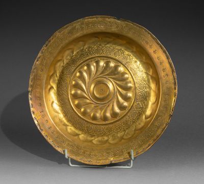 a gold plate with a circular design on a stand