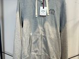 un sweat à capuche gris accroché à un portant dans un magasin de vêtements