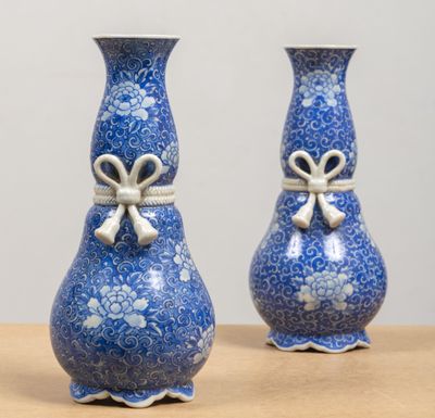 deux vases bleus ornés de nœuds, posés sur une table