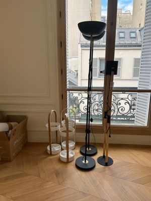 une lampe posée par terre devant une fenêtre