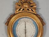 une horloge en or accrochée au mur, sur laquelle se trouve un cadran