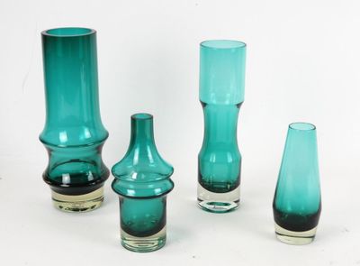 cinq vases en verre de couleurs différentes posés sur une surface blanche