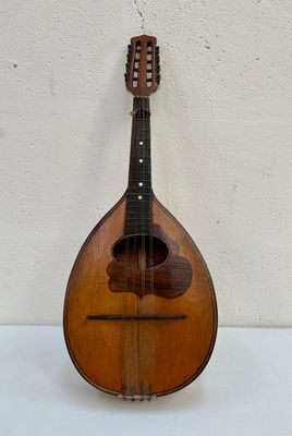 une vieille mandoline posée sur une table près d'un mur blanc