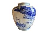 a blue and white vase sitting on a white surface