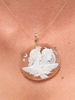 a close up of a woman wearing a necklace with an angel on it