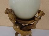 an egg sitting on top of a wooden stand on a table