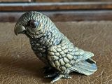 a small figurine of a parrot sitting on a table