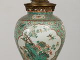 a vase with a bird on it sitting on a table