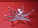 une fleur en verre transparent posée sur un fond rouge