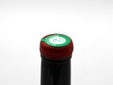 a bottle of wine that has a red cap on it