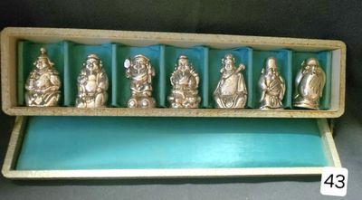 an image of a display case filled with silver figurines of buddhas