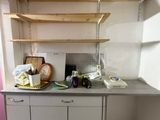 a kitchen with a sink and shelves in it