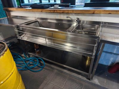 a stainless steel sink in the corner of a kitchen