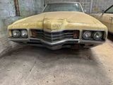 a yellow car parked in a garage next to another car