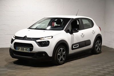 la citrole blanche est garee dans un garage au sol en damier