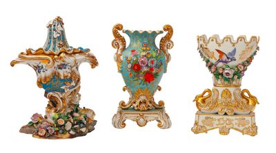quatre vases de couleurs différentes, ornés de fleurs, posés sur une surface blanche