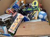 a cardboard box full of toys for sale on the street