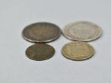 four different coins sitting on top of each other on a white surface