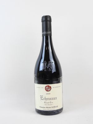 la bouteille de vin rouge est posée sur une surface blanche