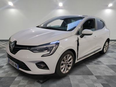 une voiture blanche est garée dans une pièce au sol à carreaux