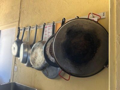 pots and pans are hanging on a wall in a kitchen