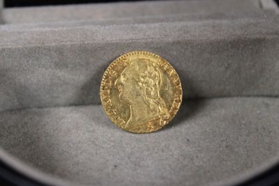 une pièce d'or posée dans une boîte sur une table