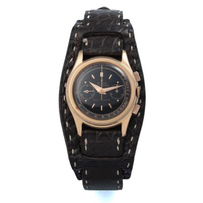 une photo d'une montre noire et dorée montée sur un bracelet en cuir noir