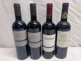 quatre bouteilles de vin sont alignées sur une table