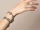 woman ' s hand with a bracelet and a ring on her wrist